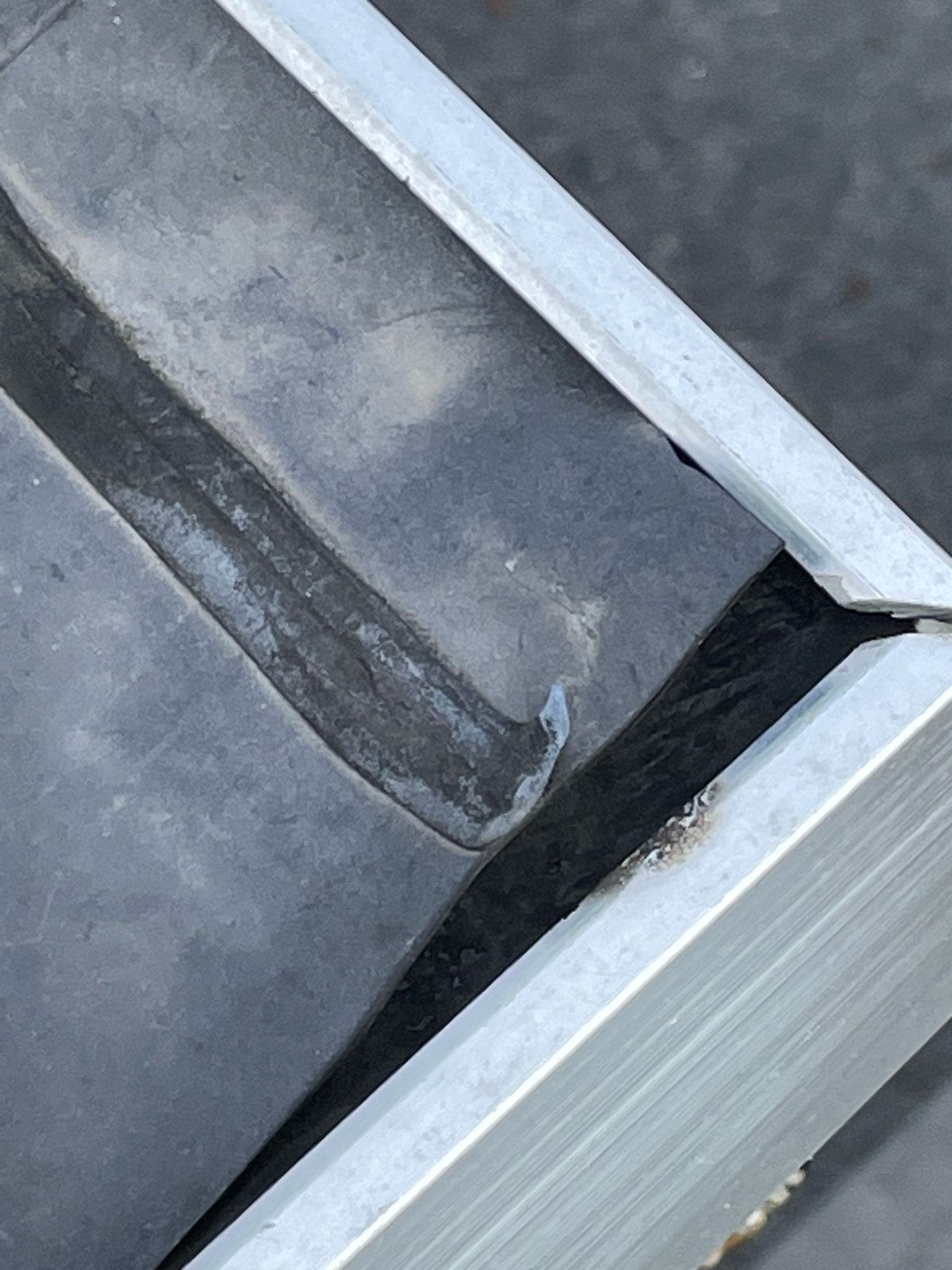 Detail van zinken dakgoot met beschadigde aansluiting